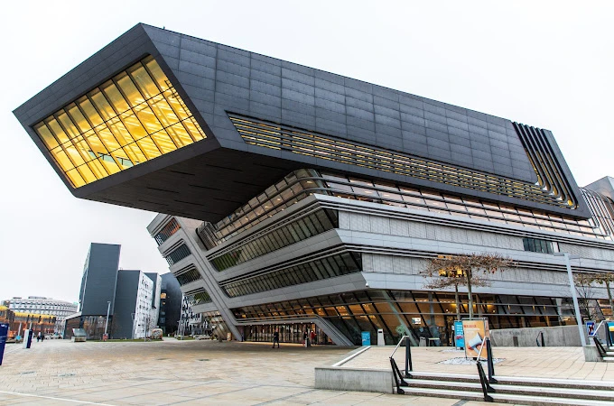 Viyana Ekonomi Üniversitesi Modern Kampüs Binası Viyana Ekonomi Üniversitesi kampüsünde yer alan modern tasarımlı ana bina, dikkat çekici mimarisiyle öne çıkmaktadır. Cam ve çelik detayların ön planda olduğu yapı, üniversitenin yenilikçi vizyonunu ve çağdaş eğitim anlayışını yansıtmaktadır. Fotoğrafta binanın asimetrik tasarımı ve geniş cam pencerelerinden yansıyan ışıklar etkileyici bir atmosfer oluşturmuştur.