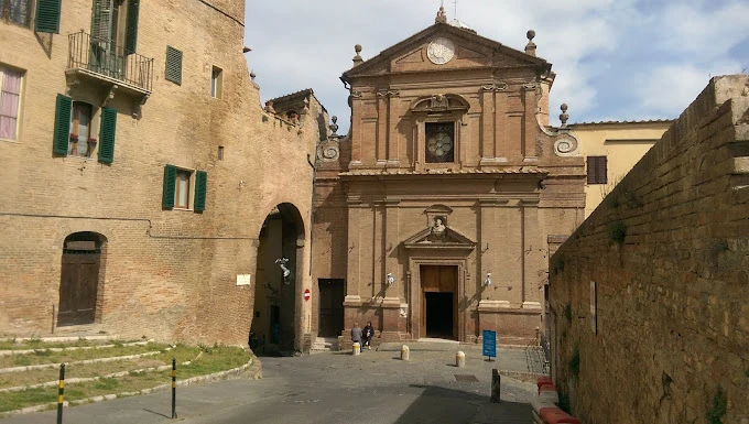 Siena Üniversitesi: Tarihi Dokular Arasında Büyüleyici Bir Yapı Siena Üniversitesi, İtalya’nın Orta Çağ atmosferini koruyan eşsiz sokakları arasında yer alan tarihi yapılarıyla dikkat çekiyor. Fotoğrafta, üniversite kampüsüne yakın bölgede yer alan görkemli taş binalar ve tarihi bir kilise cephesi görülüyor. Eski İtalyan mimarisinin izlerini taşıyan bu yapı, hem öğrenciler hem de ziyaretçiler için etkileyici bir durak.