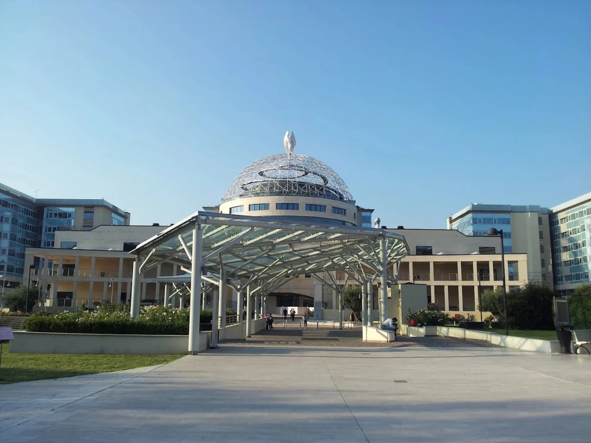 San Raffaele Üniversitesi: Modern Kampüs ve Yenilikçi Eğitim Anlayışı San Raffaele Üniversitesi, Milano’nun kalbinde yer alan modern tasarımı ve yüksek standartlardaki akademik ortamıyla öne çıkan prestijli bir eğitim kurumudur. Fotoğrafta, üniversitenin ikonik kubbe yapısı ve modern kampüs mimarisi dikkat çekiyor. Sağlık bilimleri, tıp ve araştırma alanındaki başarılarıyla dünya çapında tanınan San Raffaele Üniversitesi, öğrencilere hem teorik hem de pratik açıdan güçlü bir eğitim deneyimi sunmaktadır.