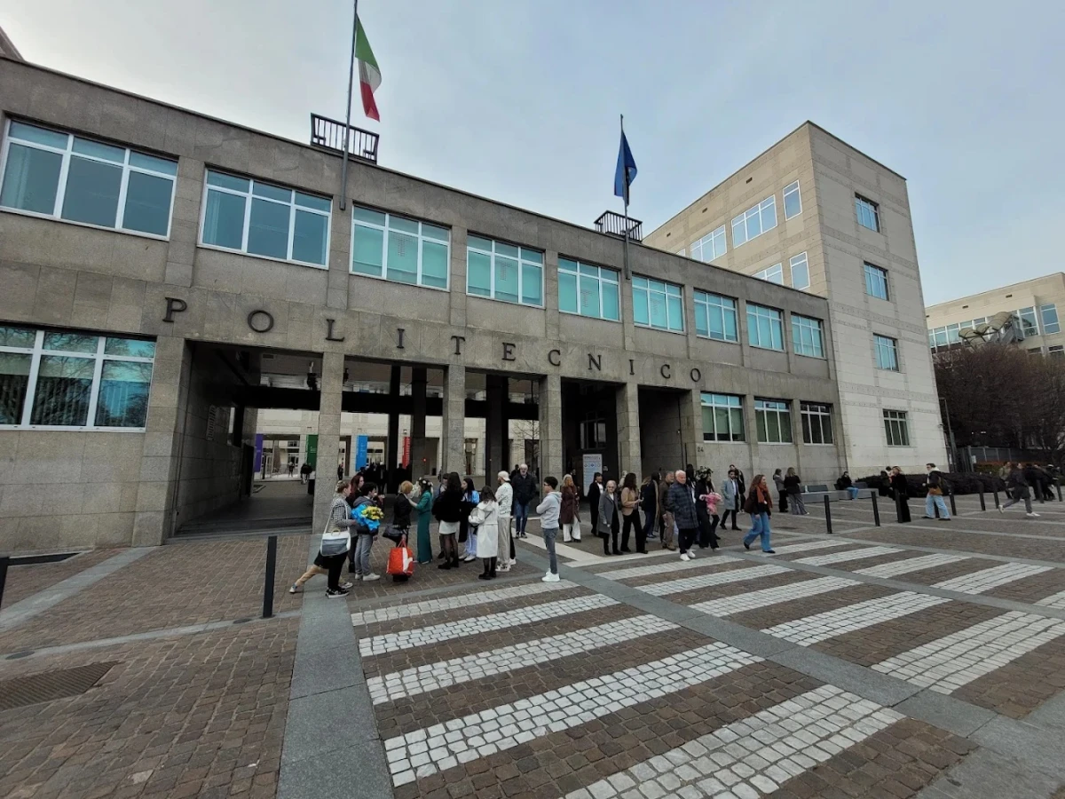 Politecnico Di Torino Ana Kampüsü – İtalya’nın Önde Gelen Teknik Üniversitesi Politecnico Di Torino, İtalya’nın en prestijli teknik üniversitelerinden biridir. Bu görselde kampüs girişinde öğrencilerin ve ziyaretçilerin yoğun olarak bulunduğu alan görülmektedir. Modern mimarisi ve geniş eğitim olanaklarıyla Politecnico Di Torino, mühendislik, mimarlık ve teknoloji alanlarında dünyanın dört bir yanından öğrencileri kendine çekmektedir.