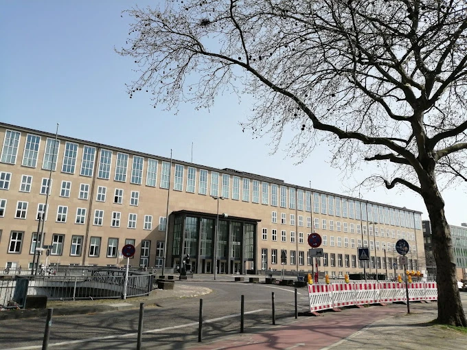 Köln Üniversitesi Modern Kampüs Binası Köln Üniversitesi, Almanya’nın en büyük ve köklü üniversitelerinden biri olarak modern kampüs yapısıyla dikkat çekmektedir. Geniş cephesi, çok sayıda penceresi ve merkezi giriş kapısıyla öne çıkan bu bina, öğrencilere hem akademik hem de sosyal açıdan güçlü bir eğitim ortamı sunmaktadır.